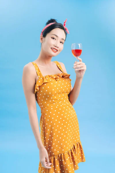 Uśmiechnięta kobieta patrząca w kamerę z czerwonym kieliszkiem wina na blu — Zdjęcie stockowe