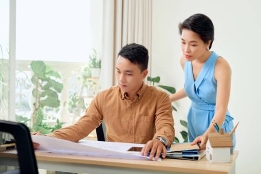 Neşeli iki mimar yeni projeyi tartışıyor.