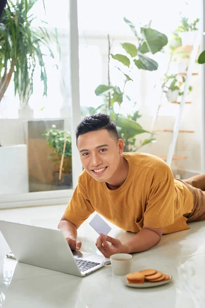 Schöner Junger Mann Mit Kreditkarte Und Lächelt Während Laptop Auf — Stockfoto