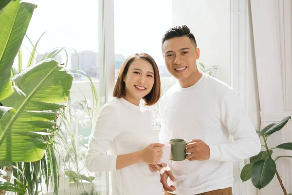 Jovem asiático casal beber café na sala de estar em casa — Fotografia de Stock