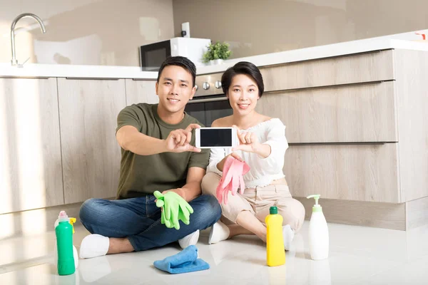 Feliz Joven Asiático Pareja Mostrando Smartphone Mientras Limpieza Casa — Foto de Stock