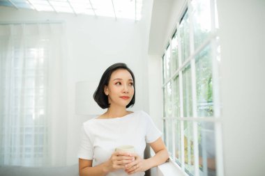 insanlar, içecek ve eğlence kavramı - fincan çay ya da kahve evde olan mutlu kadın