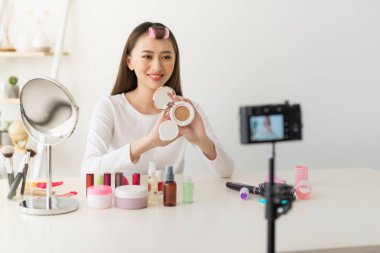 Asyalı kadın güzellik blogcusu / vlog yazarı makyaj malzemesi için öğretiyor