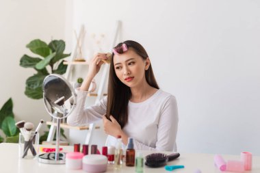 Saç eğitimi. Onun güzellik blog için bir öğretici filme iken Asyalı kadın saçlarını fırçalamak ve hoş gülümseyen