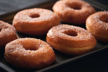 Bir barda bir tepsiüzerinde şeker ile Donuts