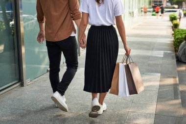 Şehrin alışveriş torbaları ile genç mutlu çift.