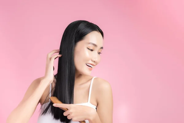 Красивая Молодая Азиатка Держит Здоровые Волосы Расчесывает Волосы Розовом Фоне — стоковое фото