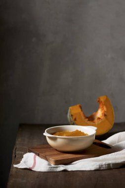 Tahta arka planda bir kasede kabak püresi