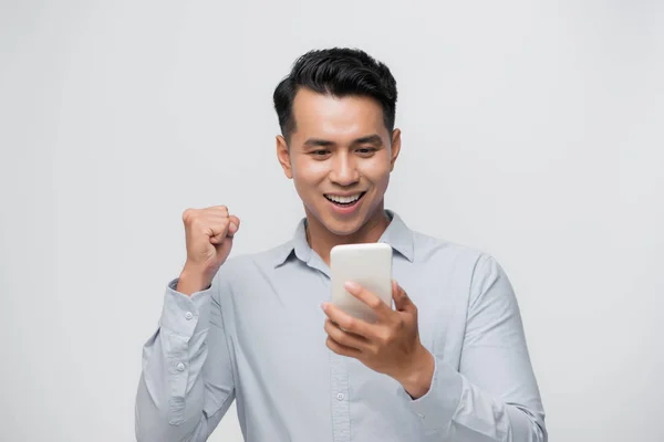 Happy Excited Asian Man Looking His Smartphone Raising His Arm — стокове фото