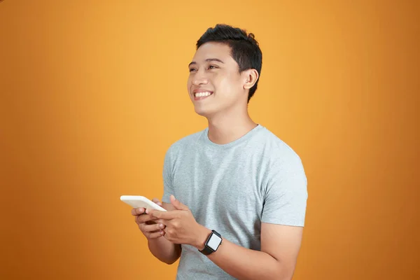 Портрет Счастливого Молодого Азиата Помощью Мобильного Телефона Студии Оранжевом Фоне — стоковое фото