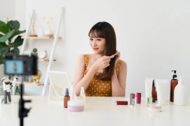 Bir blogger veya moda blogger veya vlogger aboneler için video kaydeder. Saçlara nasıl bakılabildiğini gösteriyor.