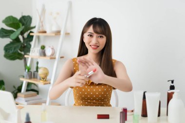 Bu nedir. Kozmetik test ederken kamera önünde oturan Pretty genç kadın