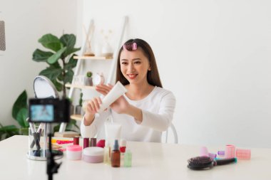 Sosyal medyada paylaşmak için kamera ile genç kadın profesyonel güzellik vlogger veya Blogger kayıt kozmetik makyaj öğretici