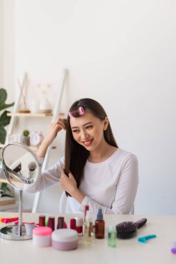 Saç eğitimi. Onun güzellik blog için bir öğretici filme iken Asyalı kadın saçlarını fırçalamak ve hoş gülümseyen