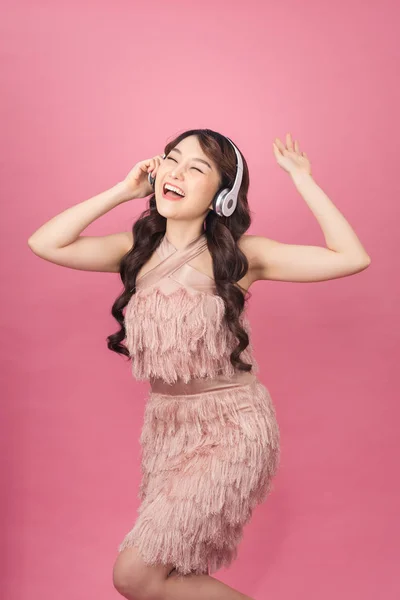 Счастливая Азиатка Наушниках Слушающая Музыку Танцующая Розовом Фоне — стоковое фото