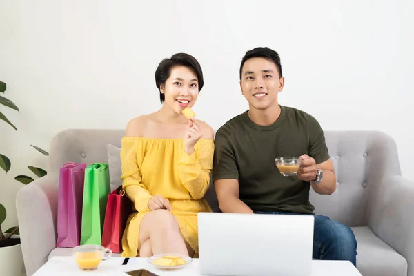 一对年轻的亚洲夫妇坐在家里的沙发上 用笔记本电脑 — 图库照片