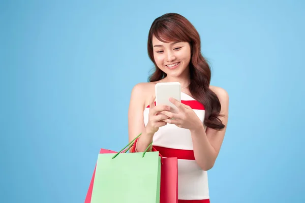 Beautiful Young Woman Using Smart Phone Shopping Online Isolated Blue Royalty Free Stock Photos