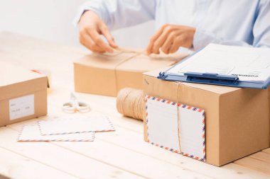 Genç işletme sahibi karton kutu paketliyor. İnternetten alışveriş hakkında.