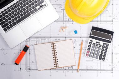 Sarı kask ve çizim araçları ile inşaat planları planları üzerinde teslim