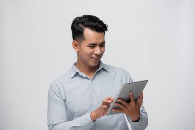 Beyaz arkaplanda izole edilmiş dijital tablet kullanan mutlu genç işadamı.