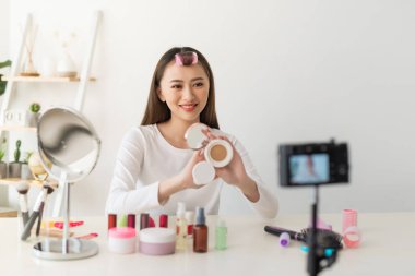 Asyalı kadın güzellik blogcusu / vlog yazarı makyaj malzemesi için öğretiyor