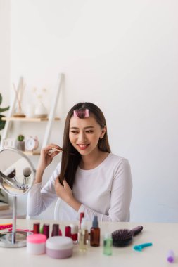 Saç eğitimi. Onun güzellik blog için bir öğretici filme iken Asyalı kadın saçlarını fırçalamak ve hoş gülümseyen