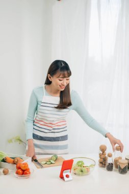 Mutlu kadın tarifi mutfakta tablet bakarak önlük. Sebze salatası. Diyet kavramı. Sağlıklı bir yaşam tarzı. Evde yemek. Yemek hazırlamak.