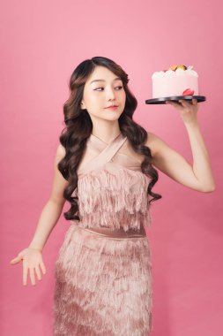 Pasta ön pembe arka plan ile neşeli kadın