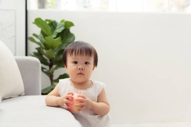 Oturma odasında kanepenin yanında duran tatlı küçük kız.