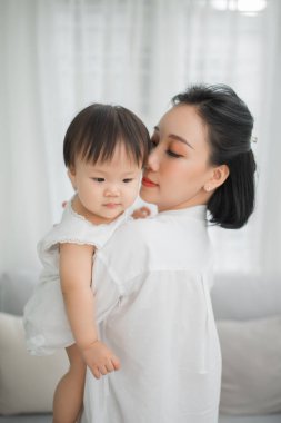Anne sarılma ve oturma odasında onun küçük kız öpüşme, Evde Kid.