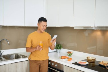 Cep telefonu tutan kahvaltı mutfak, otururken yakışıklı genç