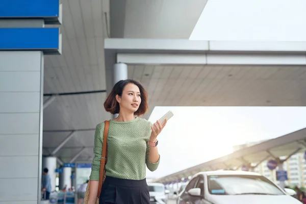 Mulher Asiática Está Verificando Seu Smartphone Como Ela Espera Aeroporto — Fotografia de Stock