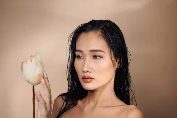 年轻健康的亚洲女子画像 手持米色背景的干荷花芽 — 图库照片