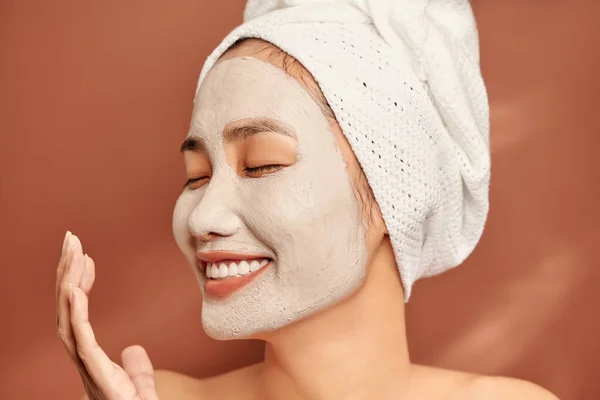 穿着水疗 头戴毛巾 戴着面部黏土面具的亚洲美女的特写 — 图库照片