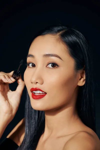 可爱可爱可爱迷人迷人迷人的积极的亚洲女人的特写 手握着时髦的黑色睫毛膏 与外界隔绝 — 图库照片