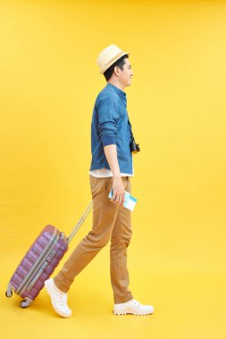 Asyalı bir adamın portresi izole edilmiş arka planda hareket işareti ile seyahat ediyor.