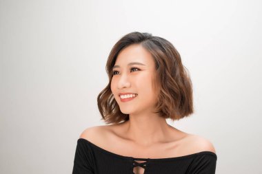 Beyaz arka planda mutlu genç bir kadının yakın plan portresi.