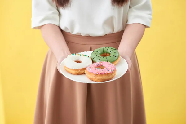 Руки Женщины Держат Вкусные Пончики Желтом Фоне — стоковое фото