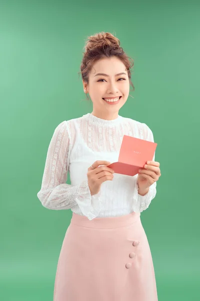 若い幸せな笑顔アジアの女性 緑の背景に隔離されたバレンタインカードを読む — ストック写真