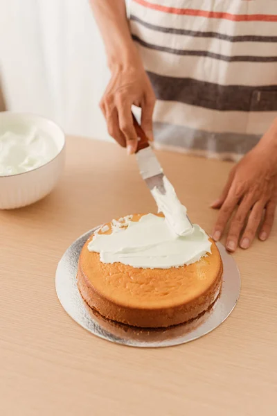 Spread the sponge cake with ice cream on wood table