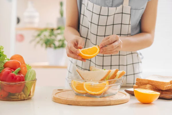 healthy eating, storage, dieting and people concept - close up of woman hands with food in glass container at home kitchen