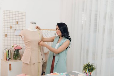 Genç Asyalı kadın moda tasarımcısı onu stüdyoda manken ölçümleri alarak