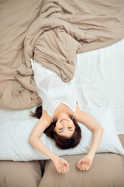 Morning of beautiful young Asian woman lying on bed at home