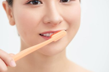 Mutlu genç bir kadın dişlerini fırçalıyor. .