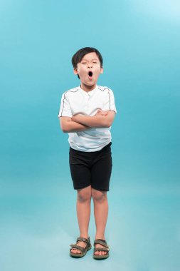 9 yaşında, kollarını kavuşturmuş, beyaz bir arka planda izole edilmiş, kendinden emin bir çocuk.