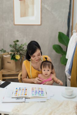 Bebekle dizlerinin üzerinde çalışan genç kadın