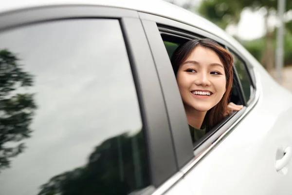 开车的女人美丽的年轻女子从车里往外看 看着相机 — 图库照片