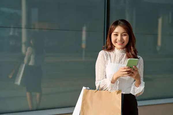 Šťastná Žena Nákupy Dívky Drží Nákupní Tašky Pomocí Chytrého Telefonu — Stock fotografie