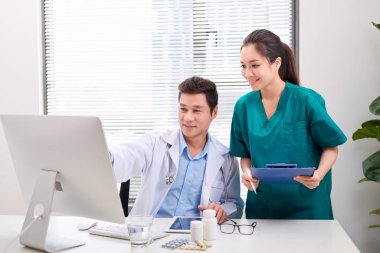 İki tıp doktoru danışmanlık, ofis masasında gülümseyen