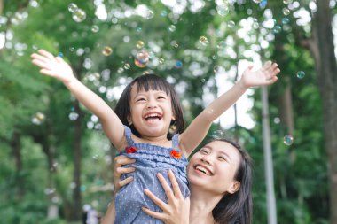Küçük kız annesi doğası ve güneş ışığı, Aile kavramı ile sarılma portresi